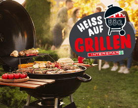 Ein mit verschiedenen Gerichten gedeckter Griller in einem Garten mit vielen verschiedenen Personen im Hintergrund