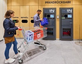 Zwei Personen beim Zurückgeben von Pfandflaschen bei INTERSPAR