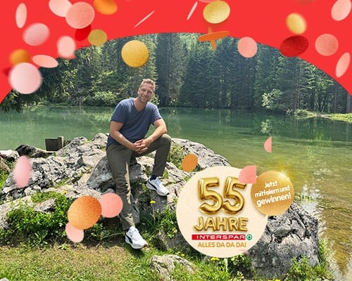 Didi Maier sitzt an einem Bergsee zur Vorstellung des Gewinnspiels 50 Jahre INTERSPAR mit Didi Maier