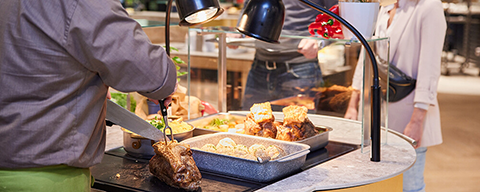 Ein INTERSPARE-Restaurant Mitarbeiter beim Servieren von Essen