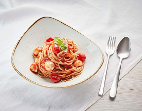 Eine Portion frischer Pasta in einem Teller auf einem Tisch