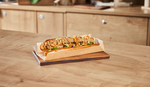 Ein Bratwurst-Hotdog mit einer Bratwurst, Sauerkraut, Senf und Zwiebeln