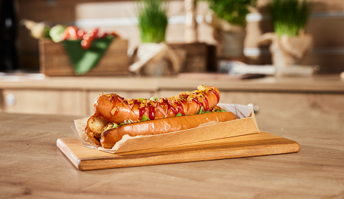 Ein Curry-Hotdog mit einer Currywurst und Currysauce in einem Brot