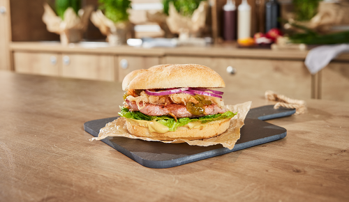 Ein Farmer's Choice Burger mit Surbraten, Kraut, Relish und Röstzwiebeln