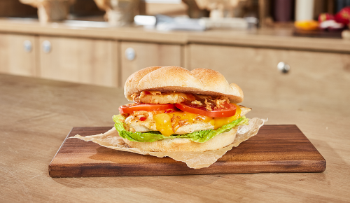 Ein grilled Chicken Burger mit Hähnchenfilet, Ananas, Tomaten und mehr