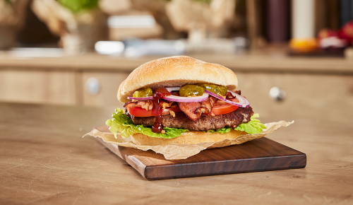 Ein Texas Bacon Burger mit Speck, Salat, Tomaten und Cocktailsauce
