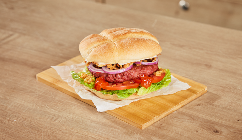 Ein veggie Burger mit einem Planted-Laibchen, Tomate und Relish
