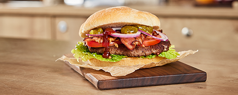 Ein Texas Bacon Burger mit Speck, Salat, Tomaten und Cocktailsauce