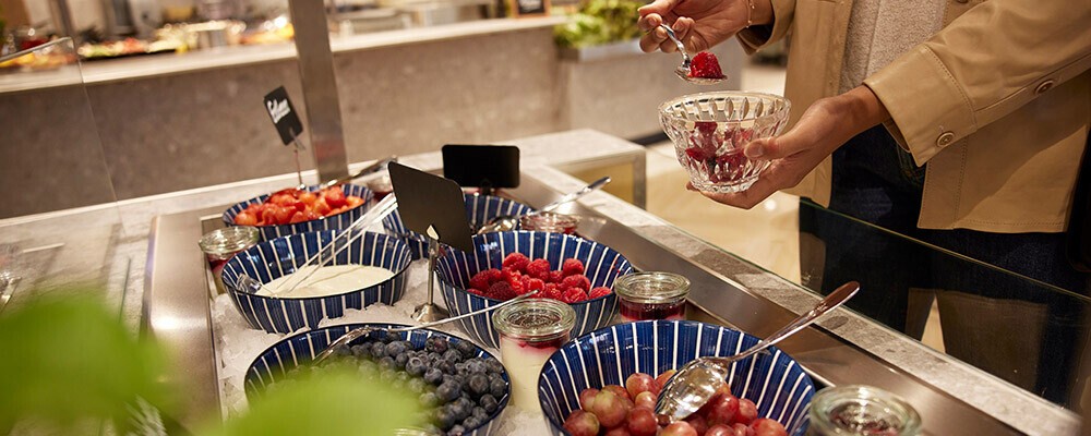 Verschiedene Schüsseln mit Beeren und Toppings für Müsli
