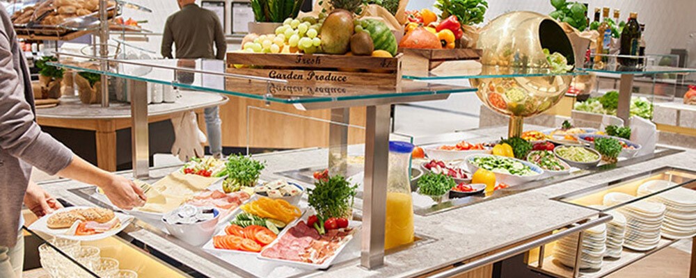 Eine Person nimmt sich etwas vom INTERSPAR-Frühstücksbuffet