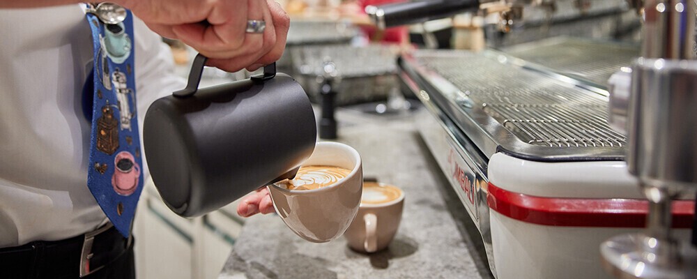 Ein Mann beim Einschenken eines Kaffees in eine Tasse