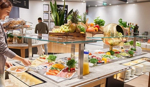 Eine Person nimmt sich etwas vom INTERSPAR-Frühstücksbuffet