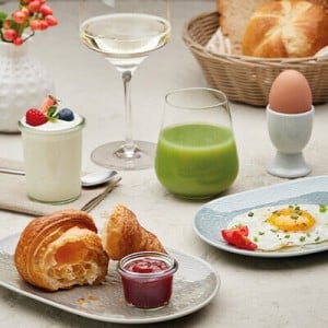 Ein angebrochenes Croissanr, ein Spiegelei, ein Glas mit Saft und mehr auf einem Tisch