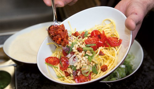 Eine frische Pasta mit Pinienkernen, Ruccola und getrockneten Tomaten