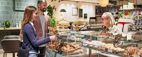 Ein Mann und eine Frau beim Bestellen an einer INTERSPAR-Kaffeebar