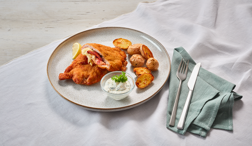 Ein gebackenes Cordon Bleu mit Ofenkartoffeln und Sauce