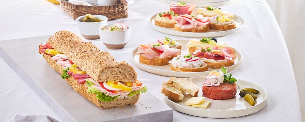 Eine gedeckter Tisch mit Riesenkornspitz und Brötchen