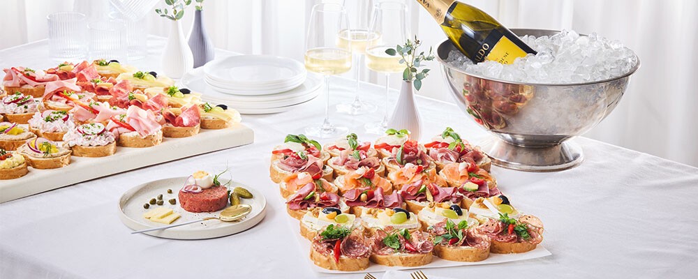 Eine gedeckter Tisch mit Brötchen-Platten und Getränken
