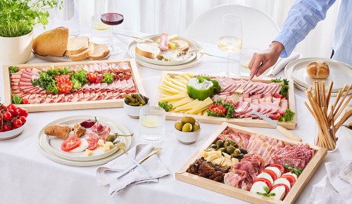 Ein gedeckter Tisch mit mit Wurstplatten und Gebäck - eine österreichische Jause aus dem INTERSPAR Partyservice