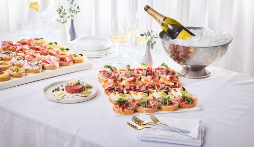 Eine gedeckter Tisch mit Brötchen-Platten und Getränken