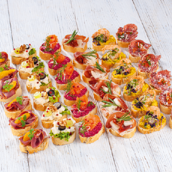 Viele verschiedene Canapés auf einem Holztisch aufgereiht