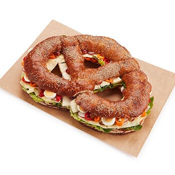 Eine Partybreze belegt mit Käse, Eier, Paprika und mehr
