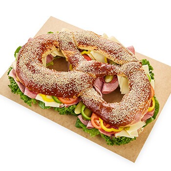 Eine Partybreze mit Sesamkörnern, Käse, Paprika, Salat und mehr
