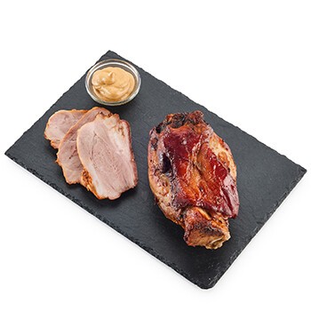 Eine gebackene Schweinshaxe auf einem Brett