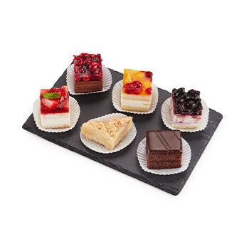 Sechs verschiedene Torten- und Kuchenwürfel auf einem Brett