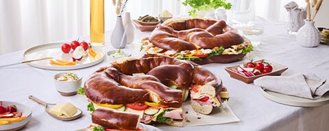 Eine gedeckter Tisch mit Partybrezen, Bier und Snacks