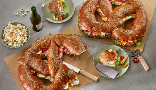 Eine große belegte Partybreze mit Käse, Eiern, Schinken, Paprika und mehr