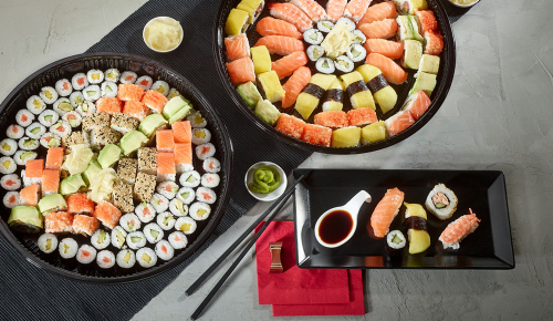 Mehrere Sushiplatten mit verschiedenen Sushi, Sashimi und Maki