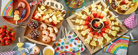 Kleine Muffins, Donuts, verschiedenes Obst und Frucht-Spieße