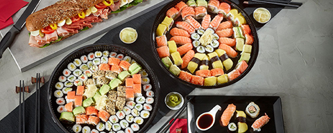 Mehrere Sushiplatten mit verschiedenen Sushi, Sashimi und Maki