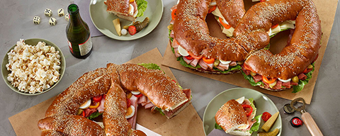 Eine große belegte Partybreze mit Käse, Eiern, Schinken, Paprika und mehr
