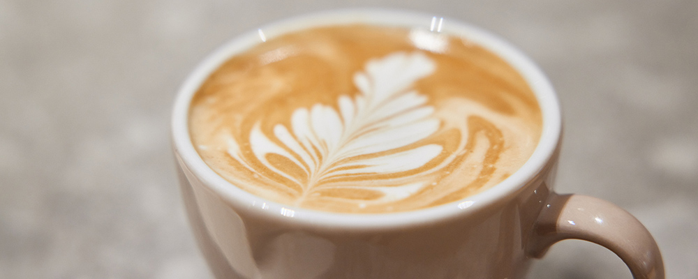 Eine Tasse Cappuccino mit einem Muster aus Kaffee