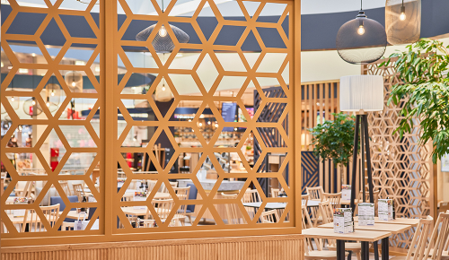 Ein Raumtrenner aus Holz in einem INTERSPAR Restaurant