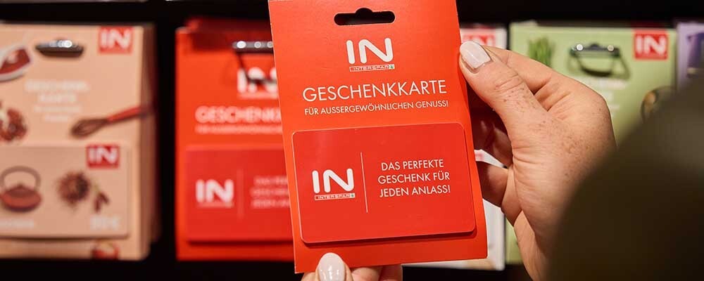 Eine Person hält eine INTERSPAR Geschenkkarte in der Hand