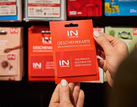 Eine Person hält eine INTERSPAR Geschenkkarte in der Hand