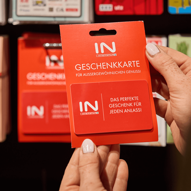 Eine Person hält eine INTERSPAR Geschenkkarte in der Hand