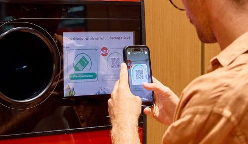 Eine Person beim Scannen des digitalen Pfandbons an einem INTERSPAR-Pfandrückgabeautomaten 