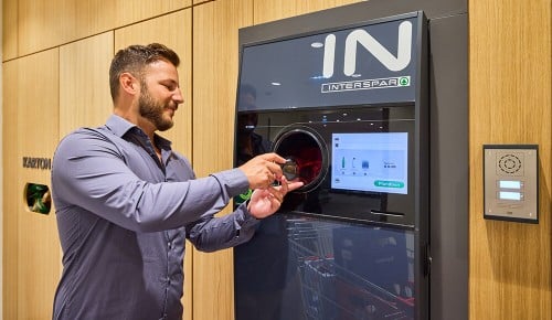 Ein Mann bei der Rückgabe einer Pfandflasche an einem Flaschenautomaten