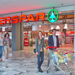 Personen mit einem vollen Einkaufswagen vor dem INTERSPAR Hypermarkt St. Pölten