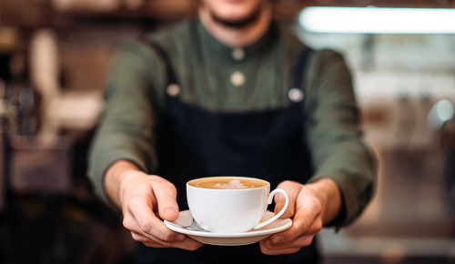 Kellner bringt eine Tasse Kaffee