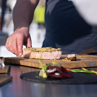 Didi Maier beim Anschneiden eines gegrillten Stücks Fleisch