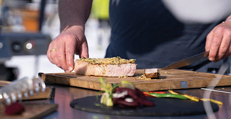Didi Maier beim Anschneiden eines gegrillten Stücks Fleisch