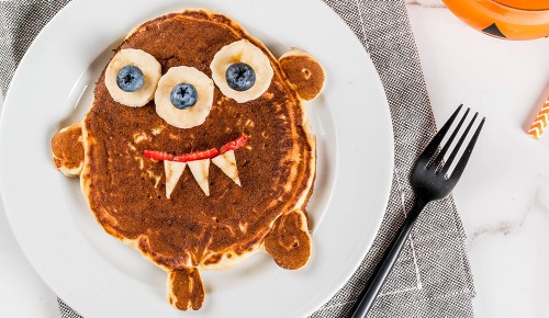 Ein Pancake mit einem gruseligen Gesicht auf einem Teller