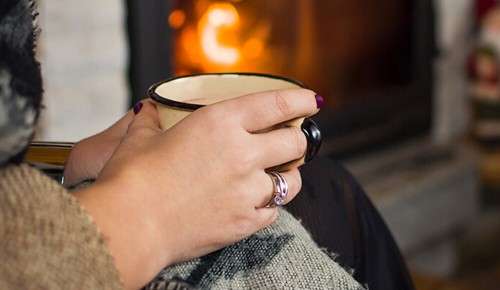 Eine Person hält eine Tasse heißen Tee in den Händen