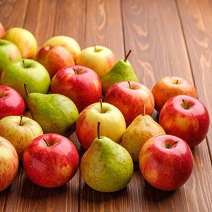 Äpfel und Birnen auf einem hölzernen Untergrund