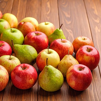 Äpfel und Birnen auf einem hölzernen Untergrund